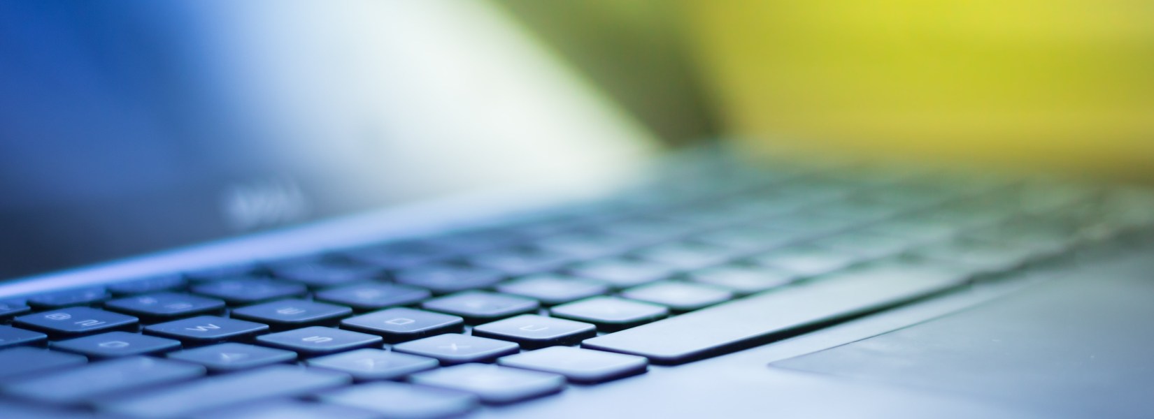 zoomed view of laptop keyboard focusing on particular keys, rest is blurred